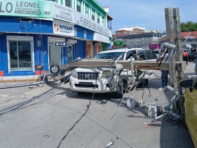 Colapsa poste eléctrico sobre dos vehículos en Barahona